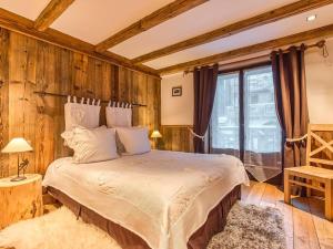 une chambre avec un lit dans une pièce aux murs en bois dans l'établissement Cosy et Spacieux 105m² à Courchevel 1850 - 6 Pers - Centre Station, Proche Pistes, Confort & Équipements - FR-1-631-162, à Courchevel