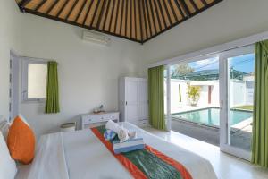 a bedroom with a bed and a view of a pool at Villa Shanti Bingin in Uluwatu +49 photos