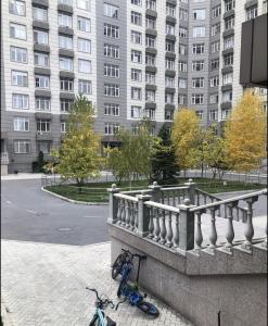 ein Fahrrad, das neben einem Geländer neben einem Gebäude geparkt ist in der Unterkunft Apartment elit Bishkek in Bischkek