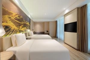 Cette chambre comprend deux lits et une télévision. dans l'établissement Atour Hotel Nanning Nanhu Subway Station, à Nanning