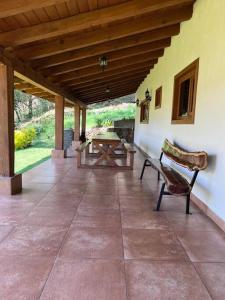 - une terrasse couverte avec un banc et une table dans l'établissement Cabaña Lety 12, à Mazamitla
