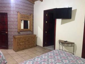 - une chambre avec un lit, une commode et un miroir dans l'établissement Cabaña Lety 12, à Mazamitla