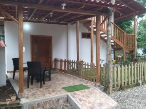 un patio con pergolato in legno, tavolo e sedie. di Nueva Tierra a Las Tunas