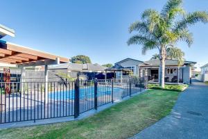 una valla frente a una casa con piscina en The Pool House Bed & Breakfast - Napier, en Napier