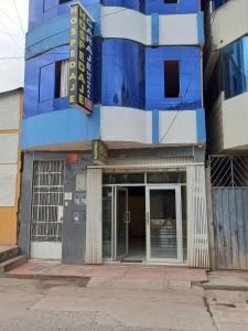 um edifício azul e branco com uma porta giratória em Hostal Garcilaso - Garaje Amplio em Abancay