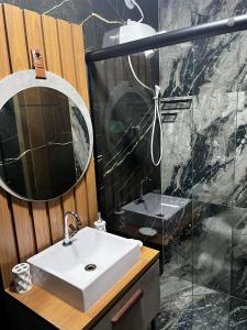a bathroom with a sink and a mirror and a shower at Meu Loft Barra Nova 3 in Saquarema