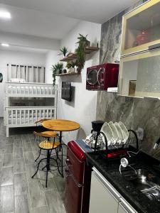 a kitchen with a table and a counter top at Meu Loft Barra Nova 3 in Saquarema