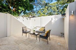 a patio with two chairs and a table and a fence at CBD Chic 3 bedroom Stay - Walk to Darling Harbour & Fish Market. (27) in Sydney
