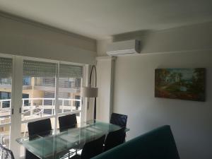 a dining room with a glass table and a window at Safira Vista Mar Apartment in Portimão