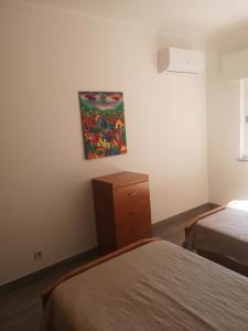 una camera con due letti e un dipinto sul muro di Safira Vista Mar Apartment a Portimão
