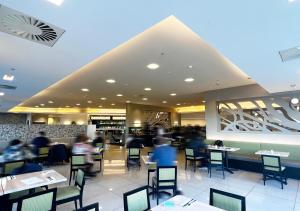 a restaurant with people sitting at tables at Sudima Auckland Airport in Auckland