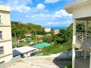 uma vista para a piscina a partir da varanda de um edifício em Skyline Suites Grenada em Grand Anse