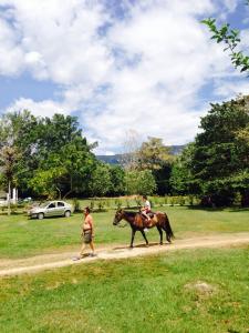 dos personas montando un caballo en un camino de tierra en Finca El Tesoro, en Carmen de Apicalá