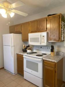 a kitchen with white appliances and wooden cabinets at B1 Guest House in Hope Mills