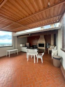 a patio with a table and chairs and a fireplace at Apartamento Moderno - Centro Luís Eduardo Magalhães - Mobiliado in Luis Eduardo Magalhaes
