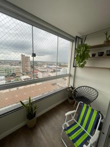 Pokój z krzesłem i dużym oknem w obiekcie Apartamento Moderno - Centro Luís Eduardo Magalhães - Mobiliado w mieście Luis Eduardo Magalhaes