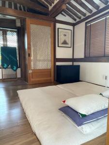 duże łóżko w pokoju z drzwiami w obiekcie Inner-Stay w mieście Tongyeong