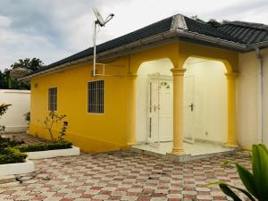 Casa blanca y amarilla con puerta blanca en villa piscine orchidée, en Pointe-Noire