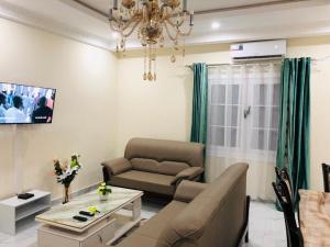 una sala de estar con un sofá y una mesa en villa piscine orchidée, en Pointe-Noire