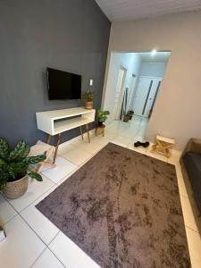 uma sala de estar com um piano branco e uma televisão em Hostel Native em Boa Vista