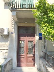 a red door with a balcony on top of a building at Apartment Martea in Split