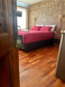 a bedroom with a large bed with red pillows at Hotel Esmeralda in La Paz