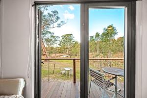 a sliding glass door with a view of a deck at Tiny Home - Redbird in Hartley