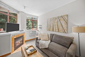 - un salon avec un canapé et une cheminée dans l'établissement Alpenglow Lodge Cozy Studio with Den by MVA, à Whistler