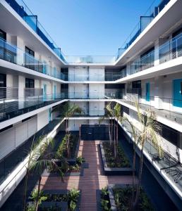 an apartment building with a courtyard with palm trees at Veriu Camperdown in Sydney