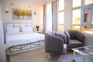 una camera con un letto e due sedie di residence queen house a Brazzaville