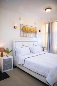 una camera da letto con un grande letto bianco e una finestra di residence queen house a Brazzaville