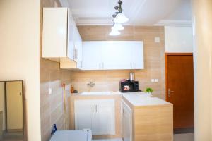 布拉薩維爾的住宿－residence queen house，小厨房配有白色橱柜和水槽