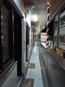 an empty hallway of a building with a sign that reads camera music at Hotel Amar in Mussoorie