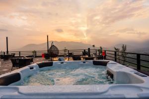 a hot tub on a deck with a view of the mountains at Sky Garden Resort in Dhulikhel
