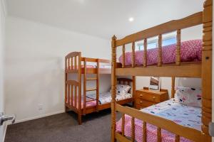 a bedroom with two bunk beds in a room at Beachfront Favourite - Foxton Beach Holiday Home in Foxton Beach