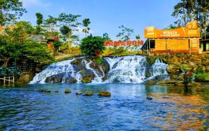 uma cascata no meio de um rio num parque temático em core inn juwita hotel em Kepanjen