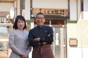 un hombre y una mujer parados frente a un edificio en Lien Tono - Vacation STAY 85593v en Tōno