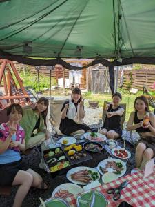 un grupo de mujeres sentadas alrededor de una mesa con comida en Lien Tono - Vacation STAY 85593v en Tōno