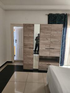 Ein Mann, der ein Foto in einem Spiegel in einem Schlafzimmer macht. in der Unterkunft appartement nid in Brazzaville