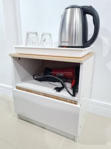 a cupboard with a tea kettle on top of it at Poonsuk Place Hotel in Bangkok Noi