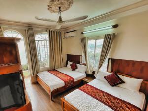 Habitación de hotel con 2 camas y TV de pantalla plana. en Quang Vinh 2 Hotel, en Nha Trang