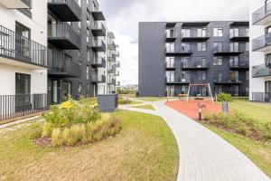 um parque com parque infantil em frente a um edifício em Ozo eco apartments em Vilnius