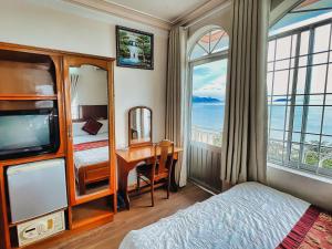 Schlafzimmer mit einem Bett, einem Schreibtisch und einem Fenster in der Unterkunft Quang Vinh 2 Hotel in Nha Trang