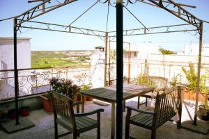 un tavolo e sedie su un balcone con ombrellone di Casa Antica Canosa a Canosa di Puglia