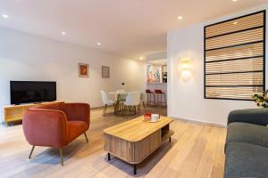 een woonkamer met een bank en een tafel bij 404 · Wonder Appart - Vue Garonne - in Toulouse
