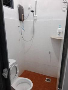 Kampong MerbokにあるDe Hampar Homestayのバスルーム(シャワー、トイレ付)、電話が備わります。