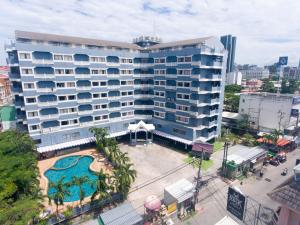 duży budynek z basenem przed nim w obiekcie Sawasdee Siam Hotel w mieście Pattaya Central