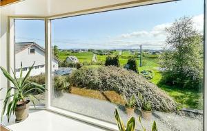 a window with plants and a view of a yard at Nice Home In Avaldsnes With Wifi And 3 Bedrooms in Avaldsnes