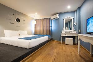 una camera da letto con un letto, un lavandino e uno specchio di Sawasdee Siam Pattaya Hotel a Centro di Pattaya Altre 15 foto