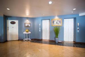 a lobby with blue walls and a table with a plant at Sawasdee Siam Hotel in Pattaya Central